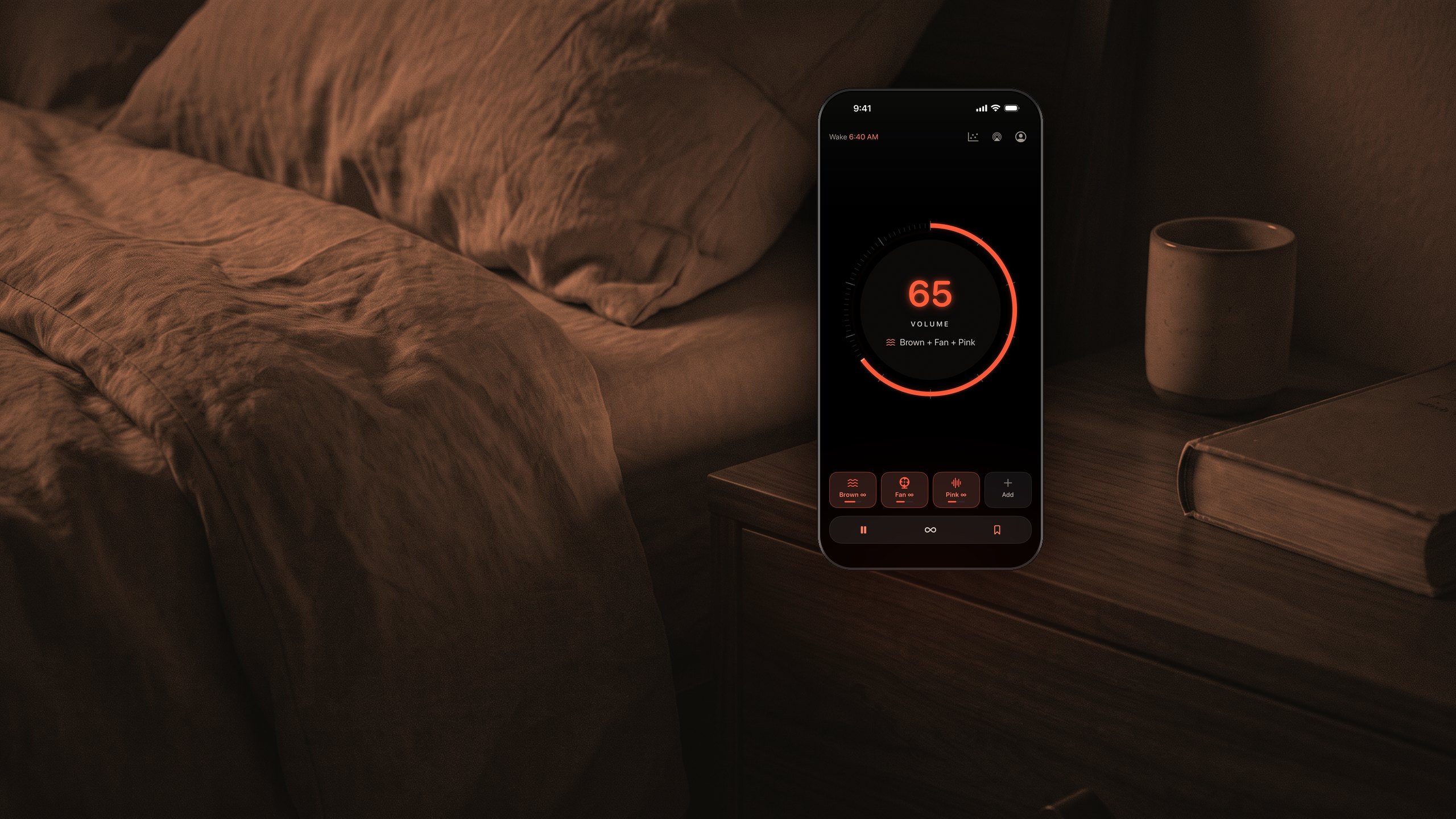 An iPhone on a walnut nightstand at
      night, its screen showing WaveSleep's dial set to 65 with Brown, Fan and Pink layered,
      the only light in a dark bedroom.